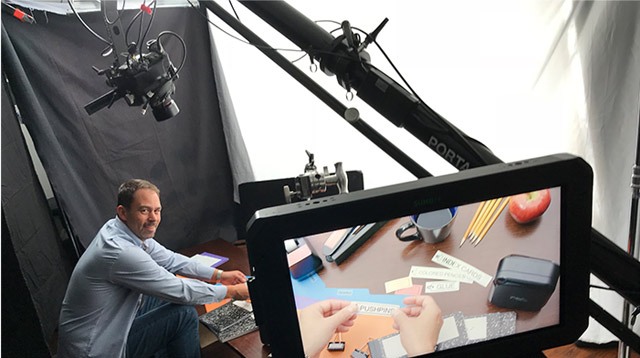 A hand model actor puts labels on a bunch of office folders in this behind the scenes image of a commmerical video production