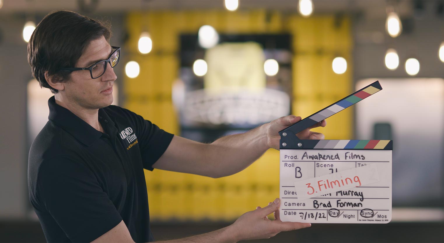a ma holds a film slate in a New Jersey Video Production Services commercial