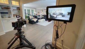 A large camera and monitor are on set for a commercial video production shoot