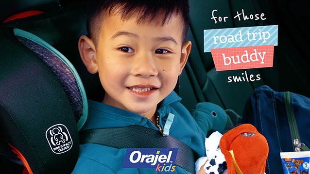 A boy smiles from a car seat during 'road trip style' video commercial shoot