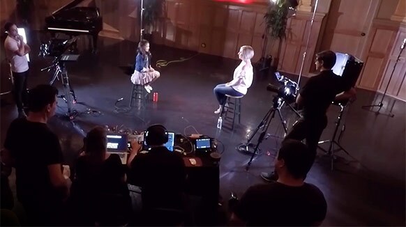 A young female singer is interviewed during a social media live event video