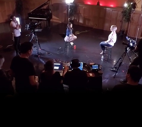 A young female singer is interviewed during a social media live event video