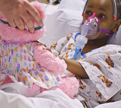 A young african american child receives hospital treatment while being filmed for a medical video production