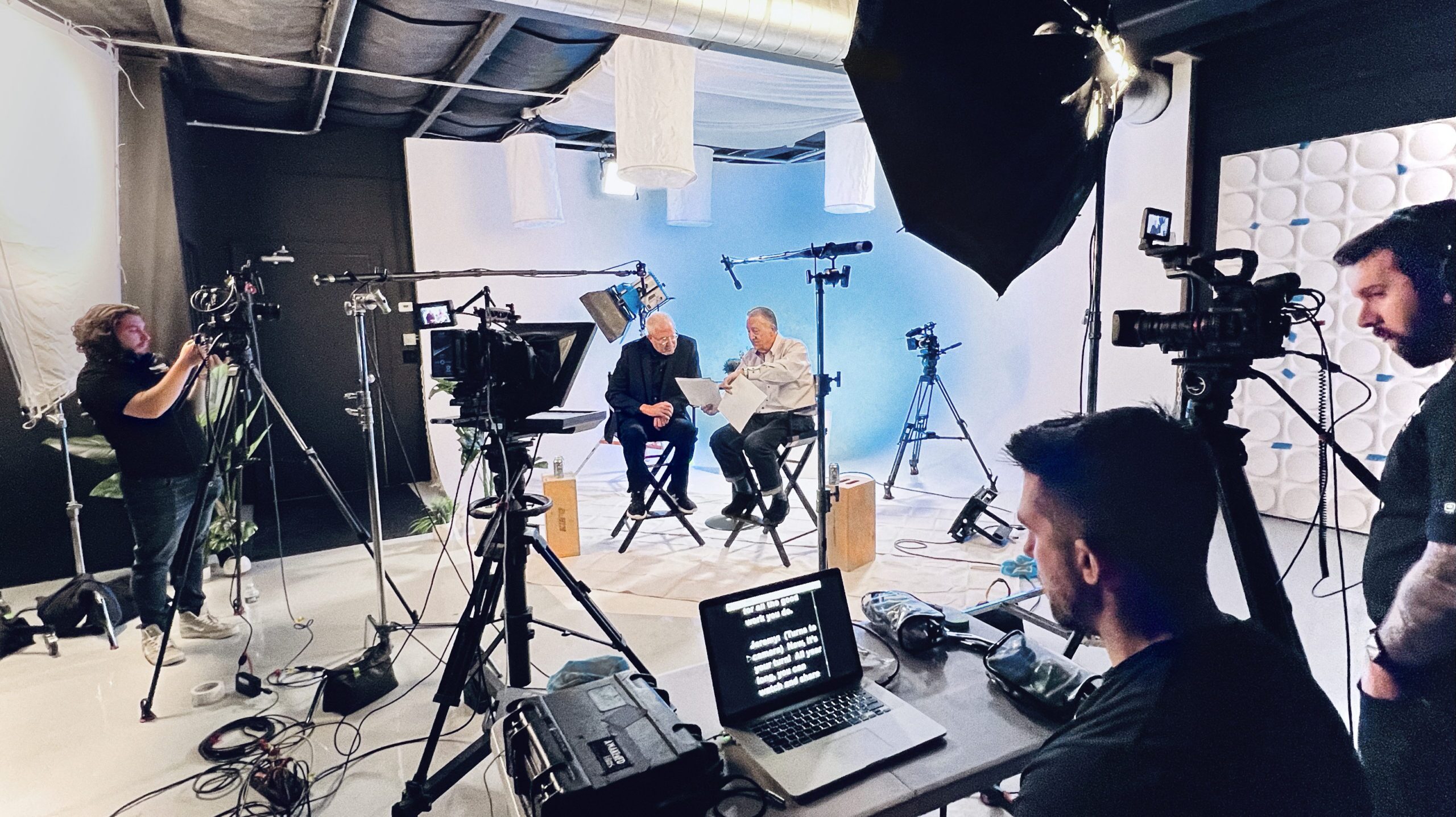 A new jersey video produciton company's studio is full of crew, gear and talent reviewing script