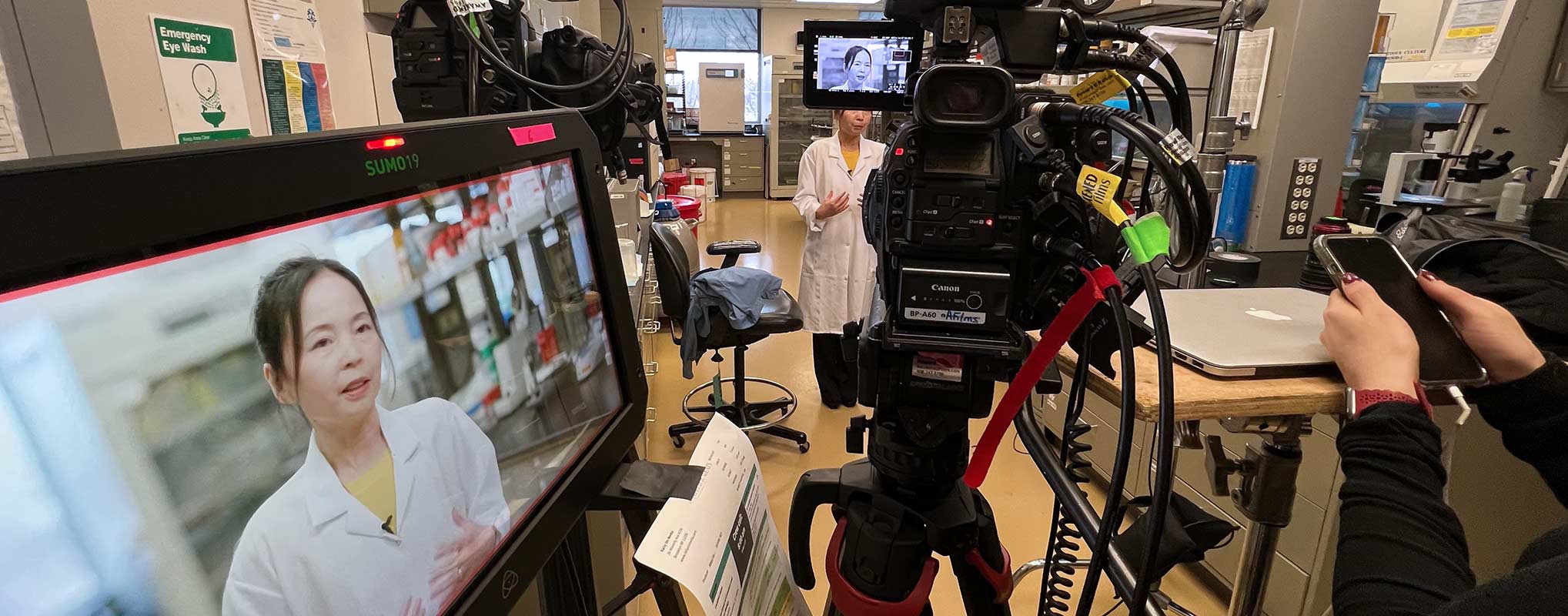A corporate video production taks place in a lab with cameras and a monitor
