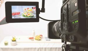 A camera films tabletop products for a NJ commercial studio