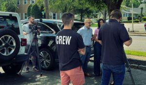 Video marketing crew setup a shot with actors in a parking lot