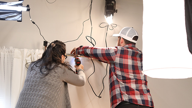 crew member hangs a light for a commercial