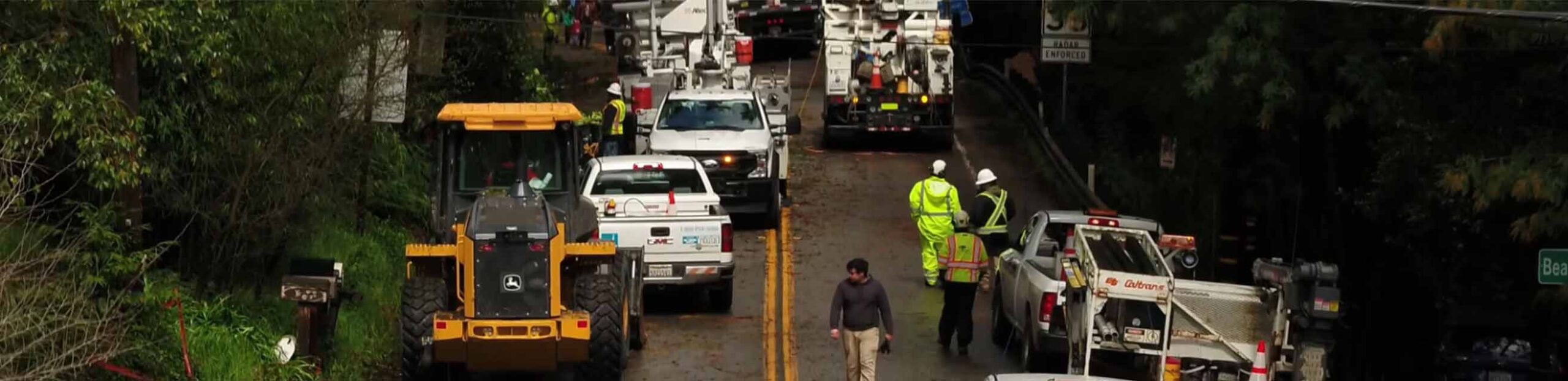 workers walk around a road after a heavy storm