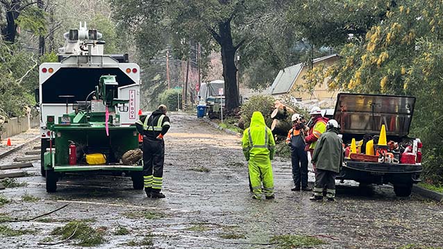 Employees work on clearing the road after a big storm