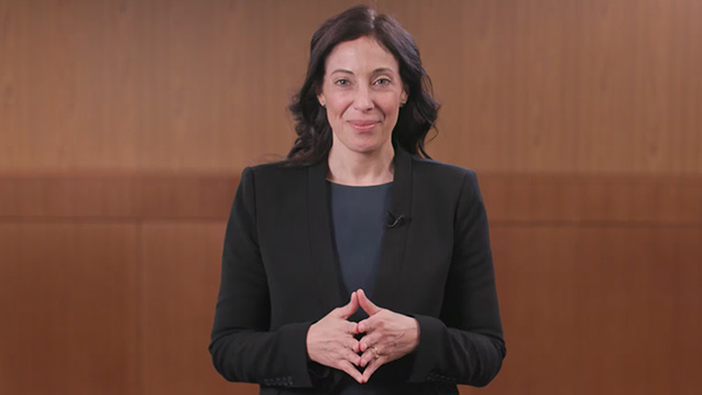 a woman poses while being filmed for a corporate video production