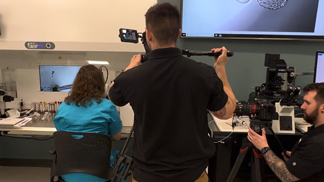 two nj video company crew members film a woman in a medical laboratory