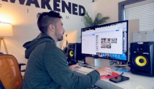 A crew member at Awakened Films works on pre-production with an apple mac studio computer