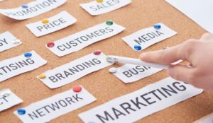 A NJ Social Media Marketer points her pencil at the word "branding" on a corkboard.