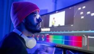 A pos-production professional works stares at a color grading monitor